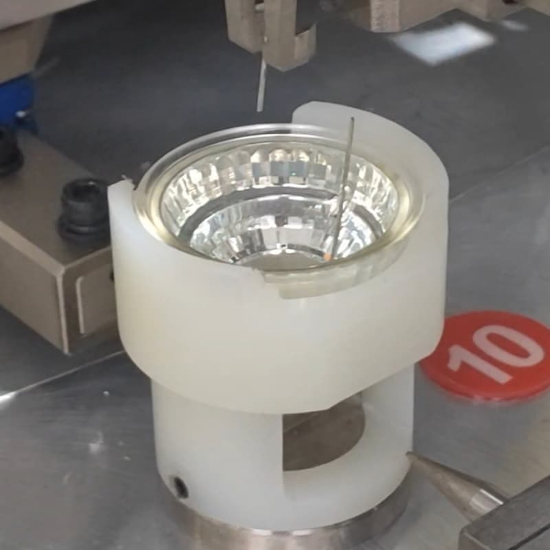 Synrit GU10 lamp base pin machine - close-up of riveting station, automated LED base assembly equipment